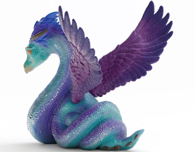 Eine farbenfrohe Drachenfigur mit blau-lila Schuppen, Flügeln und Kopf. Sie sitzt und blickt zur Seite, vor weißem Hintergrund.