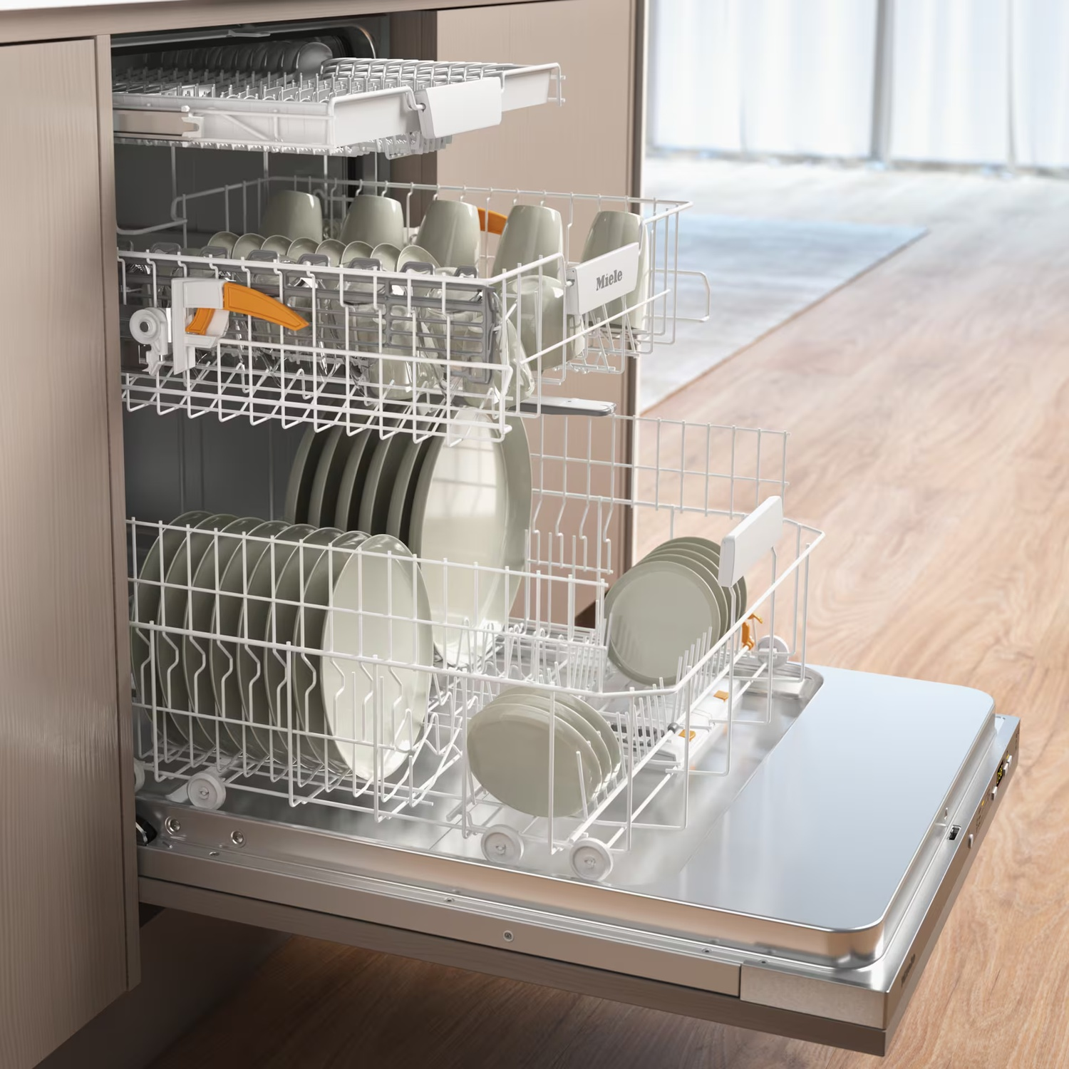 Dishwasher open, filled with plates and cups. Beige and white dishware. Stainless steel interior, wooden floor, and light beige cabinet.