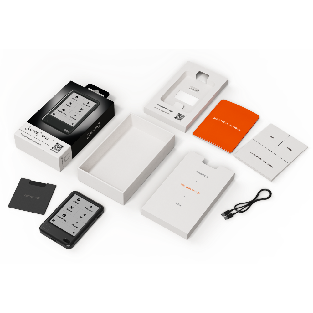 Hardware-Wallet Ledger Nano, Kartons, Wiederherstellungsblätter, Kabel und Broschüren sind auf einer gemusterten Oberfläche angeordnet.
