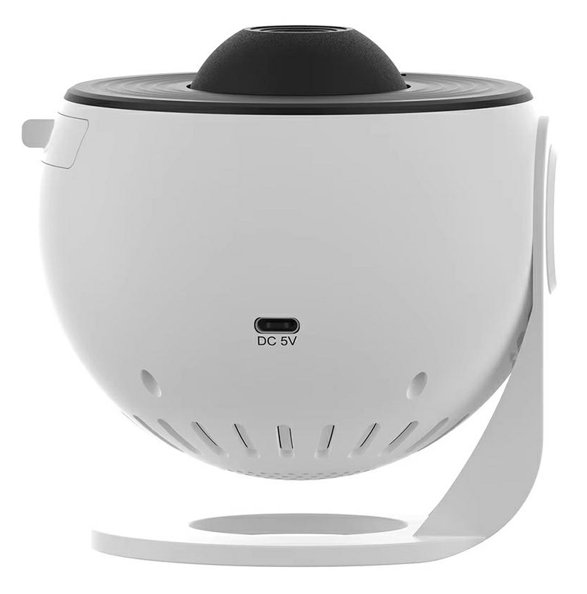 Biało-czarny projektor gwiazd. Ma okrągły kształt, czarną górę i białą podstawę ze stojakiem. Widoczny port DC 5V.