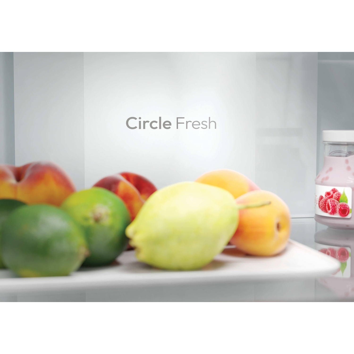 All'interno di un frigorifero: lime, pesche, limoni e un vasetto di yogurt. Lo sfondo ha un logo 'Circle Fresh'.