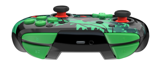 Ein grün-schwarzer Videospiel-Controller. Grüne Knöpfe und Joysticks mit roten Akzenten, Blättermuster oben.