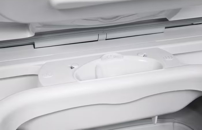 Zbliżenie białego uchwytu lodówki i otaczających go części. Uchwyt jest zakrzywiony i znajduje się w strukturze drzwi.