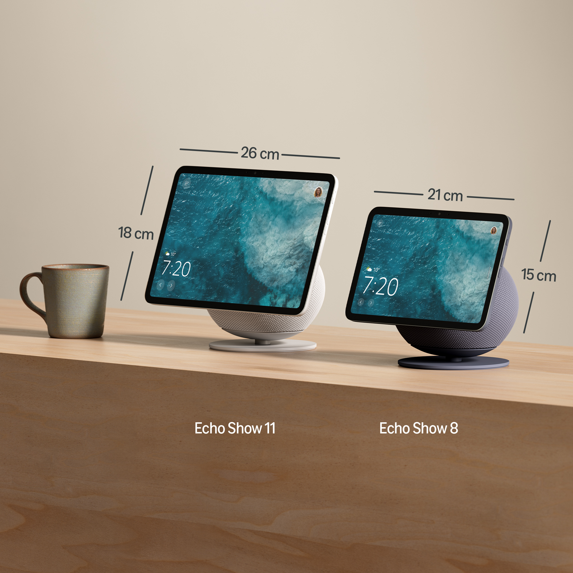 Dos pantallas inteligentes, Echo Show 11 y 8, en una superficie de madera. Una taza a la izquierda. Pantallas muestran la hora y agua.