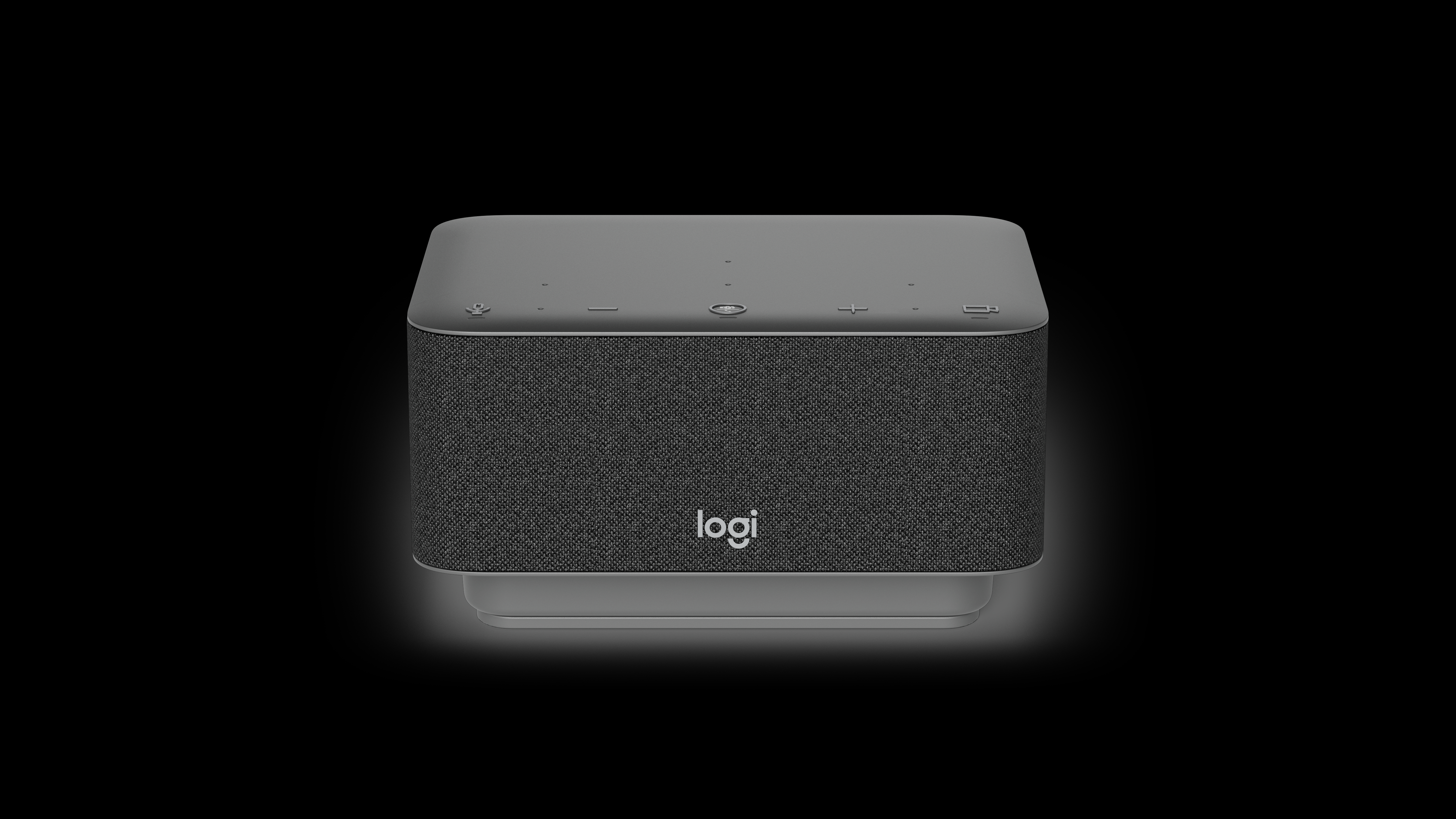 Dunkelgrauer Logitech-Lautsprecher auf schwarzem Hintergrund. Der Lautsprecher hat eine Stoffseite mit Logi-Logo.