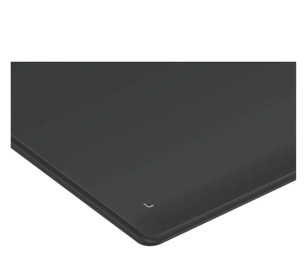 Zbliżenie czarnej, błyszczącej powierzchni, prawdopodobnie płyty grzewczej. Mały biały symbol w prawym dolnym rogu.