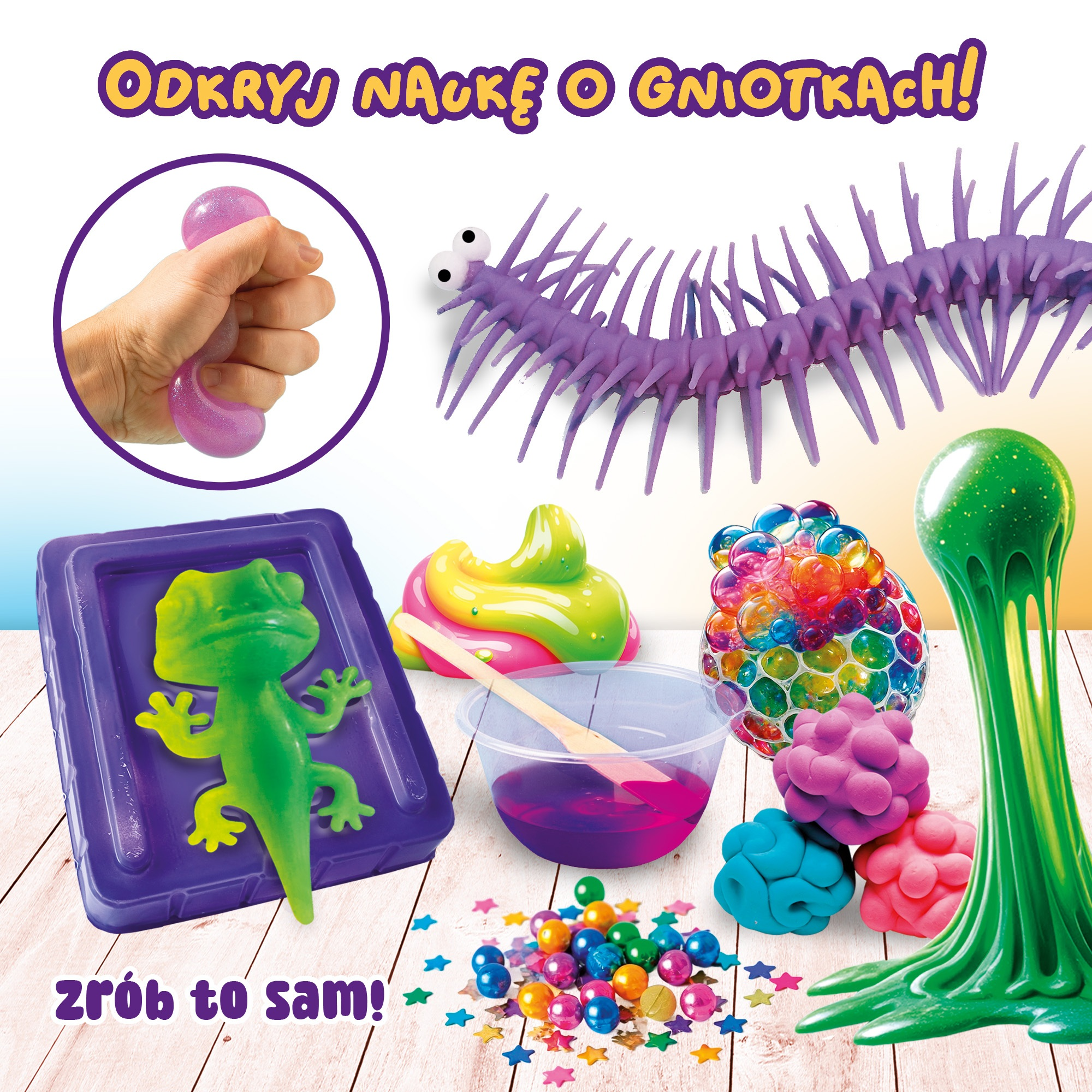 Obraz przedstawia zabawki antystresowe. Zawiera slime, zieloną jaszczurkę w pojemniku, kolorowe kulki i dłoń ściskającą zabawkę.