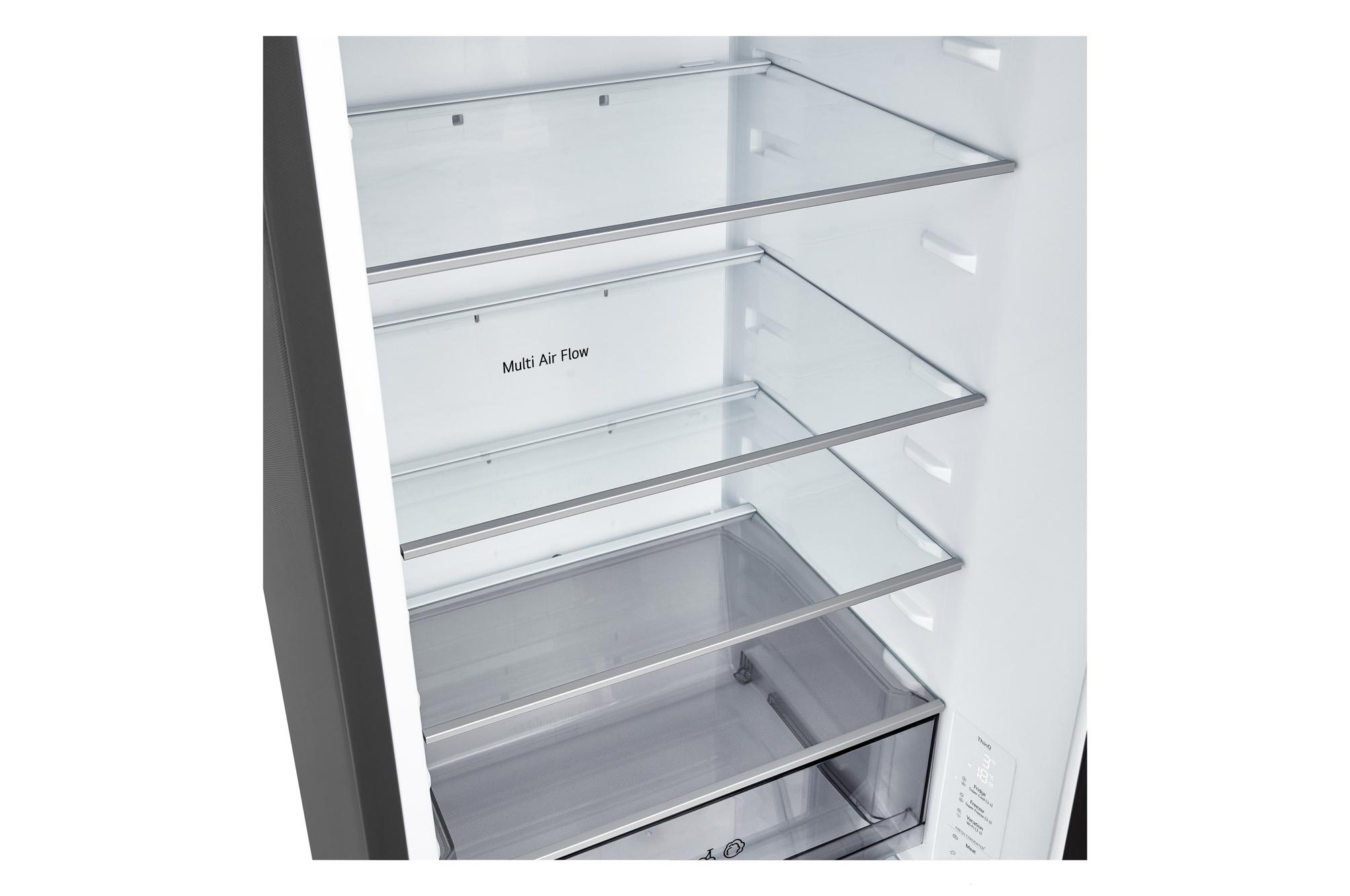 Im Inneren eines Kühlschranks mit Glasböden. Der Text 'Multi Air Flow' ist sichtbar. Der Boden hat eine Schublade. Weißes Innere.