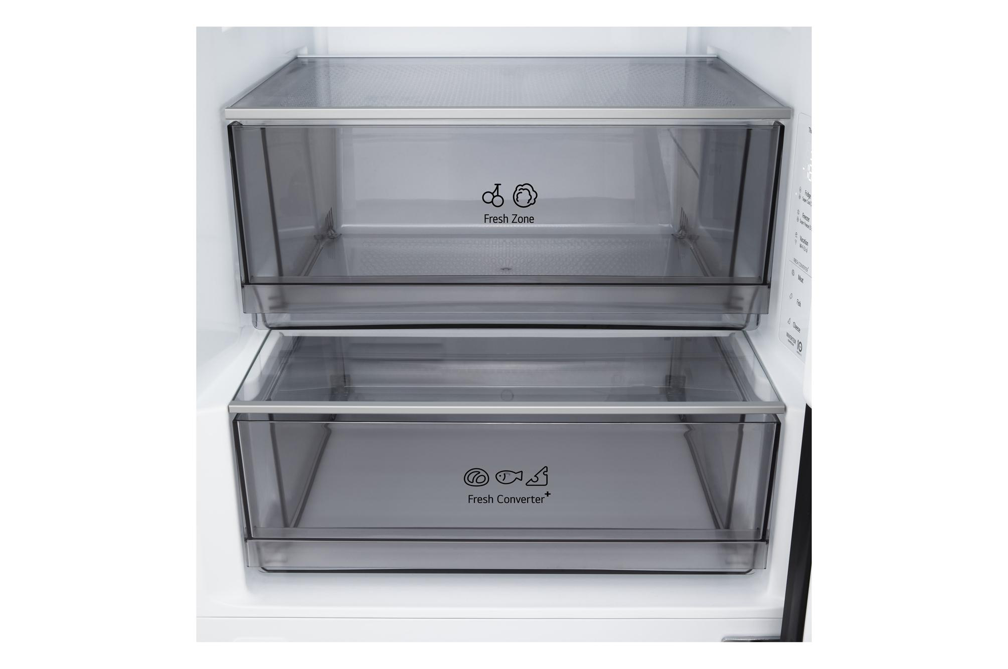 Im Kühlschrank befinden sich zwei transparente Schubladen mit der Aufschrift 'Fresh Zone' und 'Fresh Converter'. Weißes Interieur.