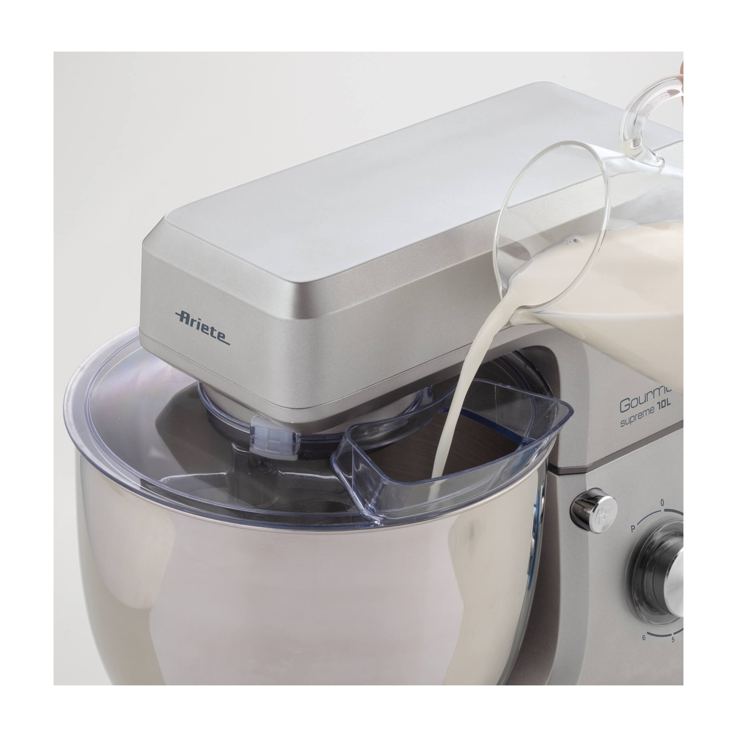 Un mixer Ariete Gourmet Supreme 10L argentato. Il latte viene versato nella ciotola da un boccale di vetro.