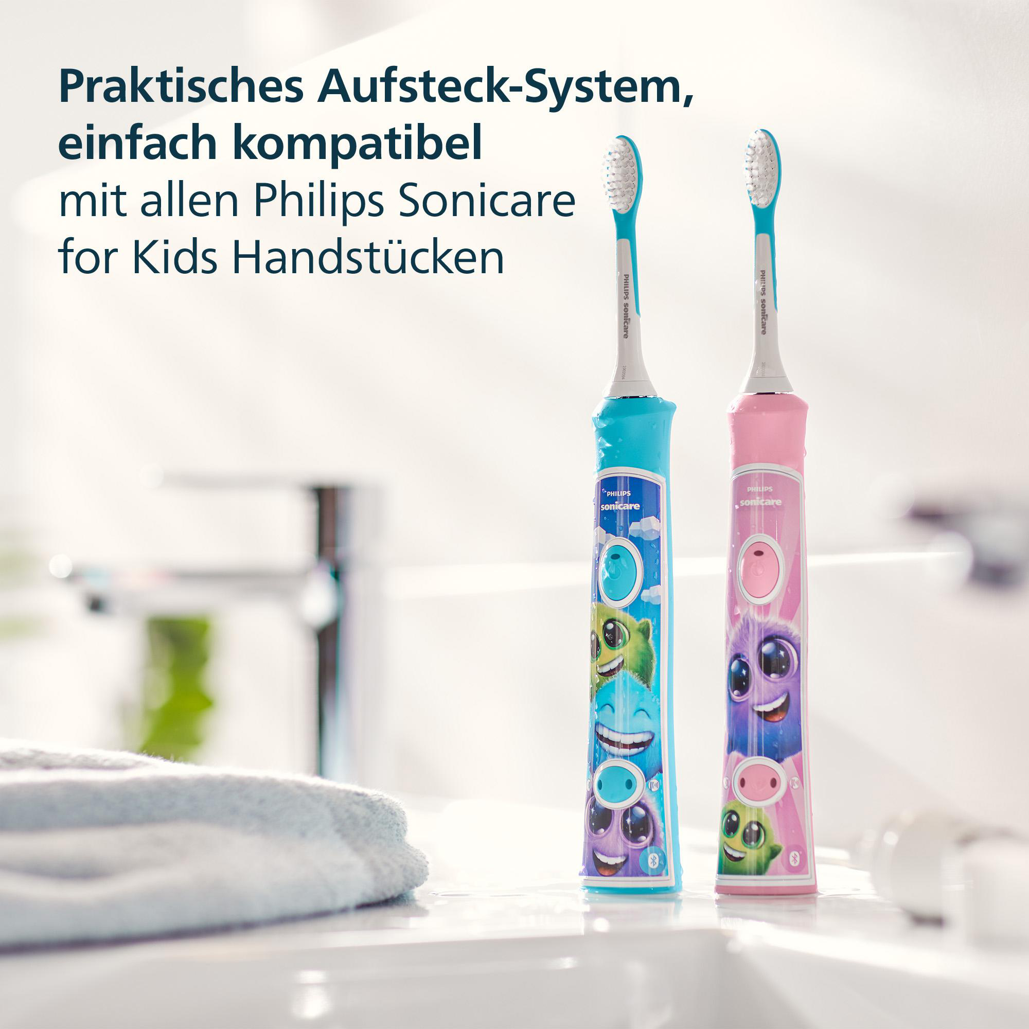 Zwei bunte Philips Sonicare Zahnbürsten für Kinder, blau und rosa, mit Cartoonfiguren, in einer Badezimmereinstellung.