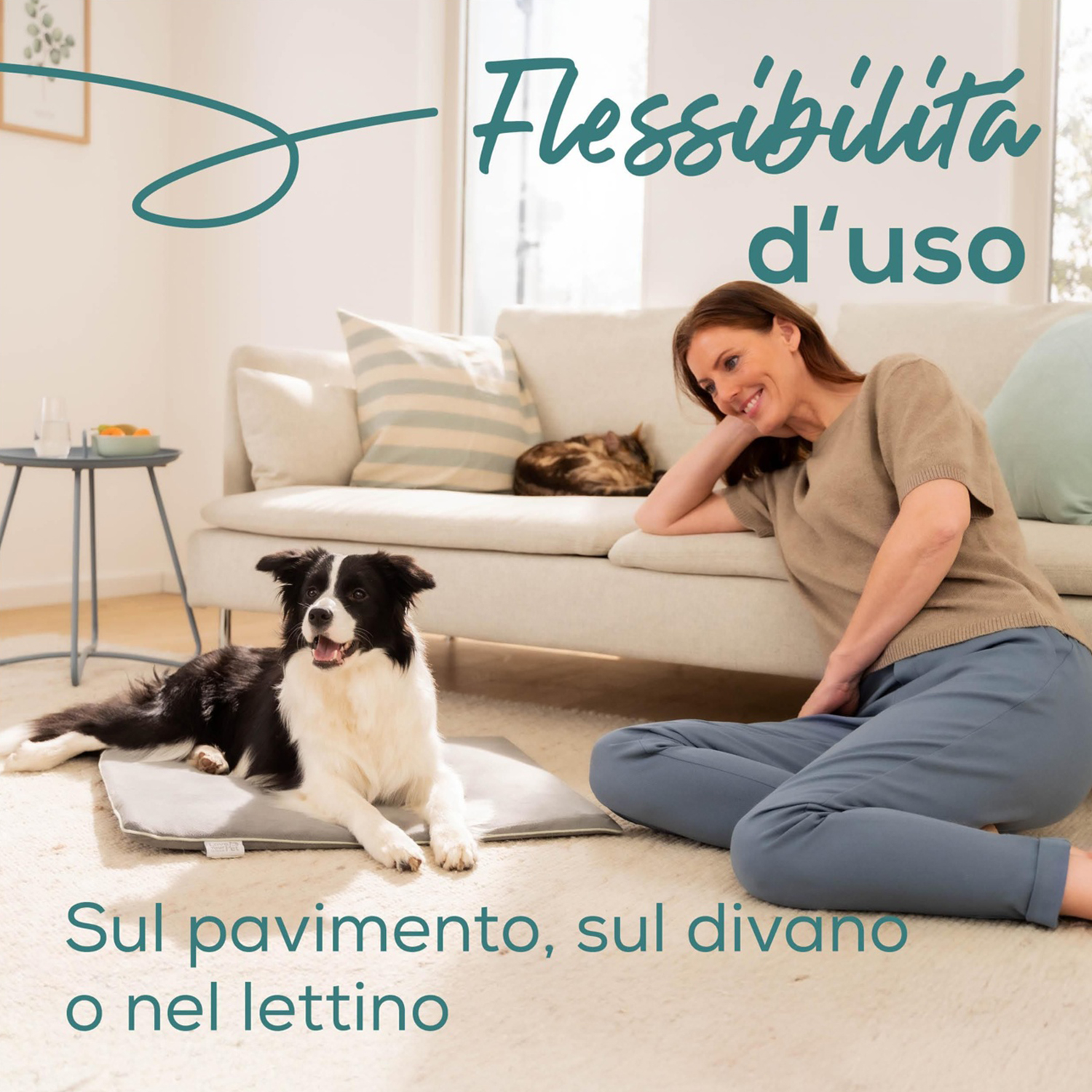 Donna e cane sul pavimento. Un gatto sul divano. Testo: 'Flessibilità di utilizzo'. Il cane è su un cuscino grigio.