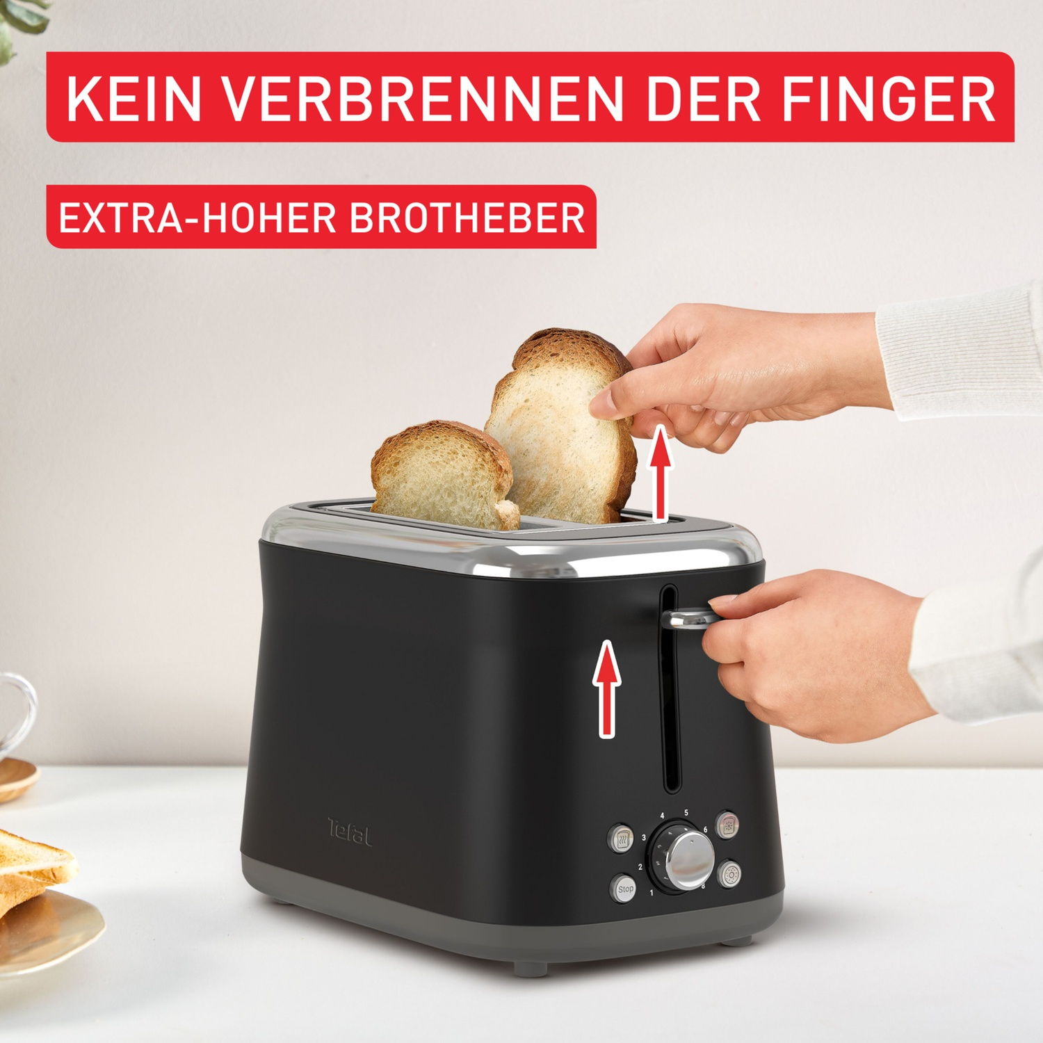 A toaster with two slices of bread. A hand pulls up the toast. Text says 'Extra-high toast lift' and 'No burnt fingers'.