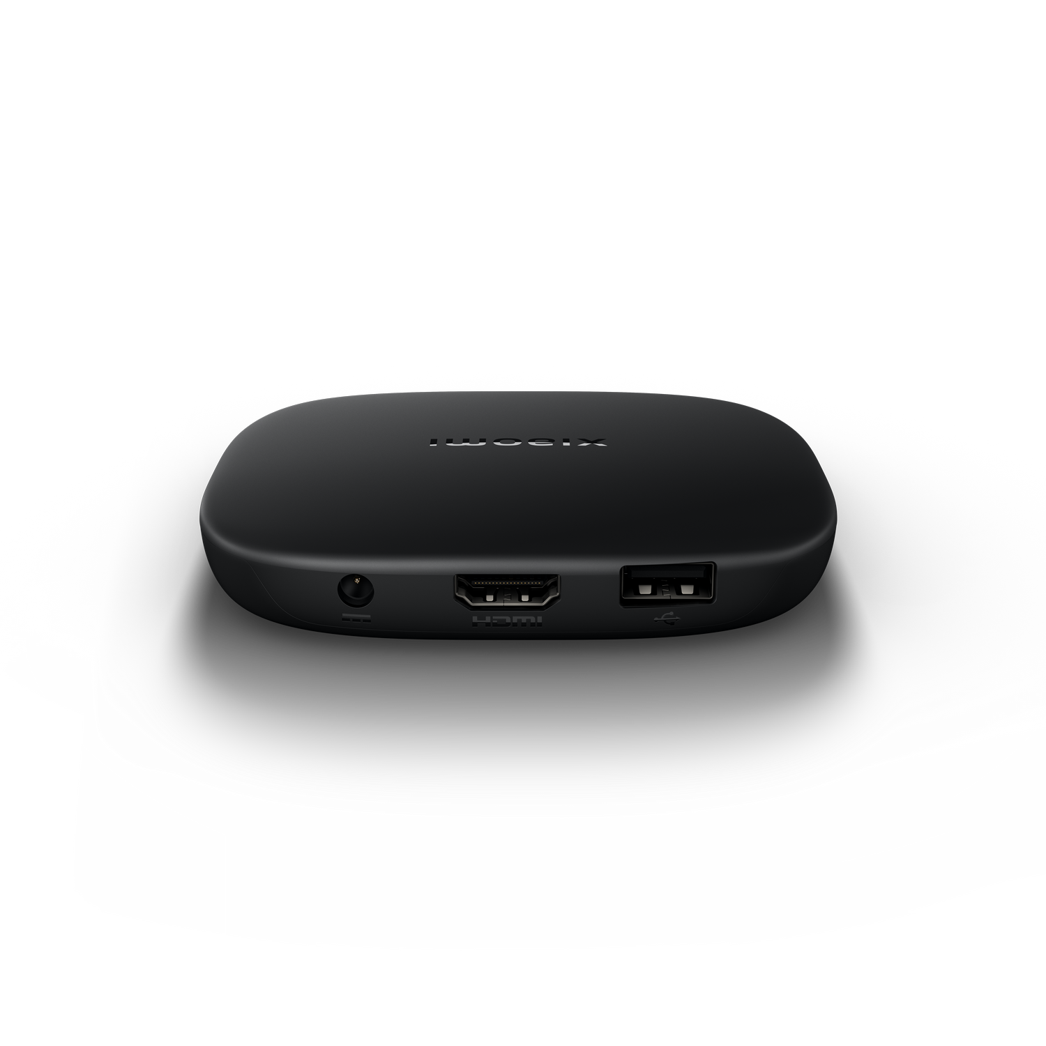 Un dispositivo de transmisión multimedia negro con puertos visibles. El fondo es un degradado de gris y negro.
