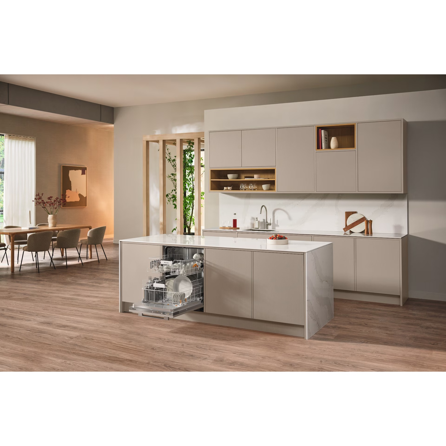 Une cuisine moderne avec lave-vaisselle ouvert, îlot et placards. Une table à manger est visible en arrière-plan.