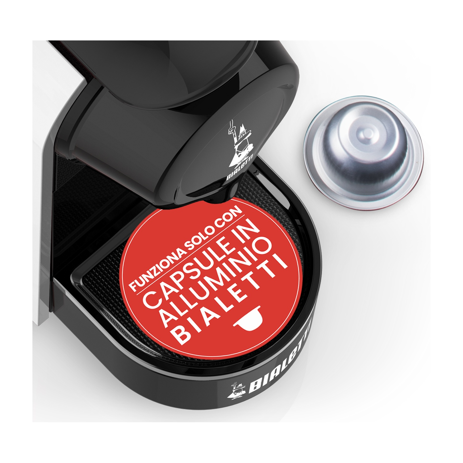 Una macchina da caffè Bialetti nera, con un disco rosso che dice 'Capsule in Alluminio Bialetti', e una cialda di caffè argentata su bianco.