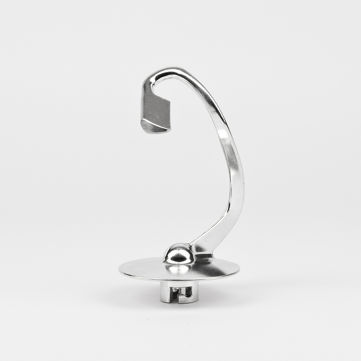 Un accessorio per mixer argentato e lucido si erge su uno sfondo bianco. Ha un braccio curvo, una base a disco piatto e un'estremità a forma di gancio.