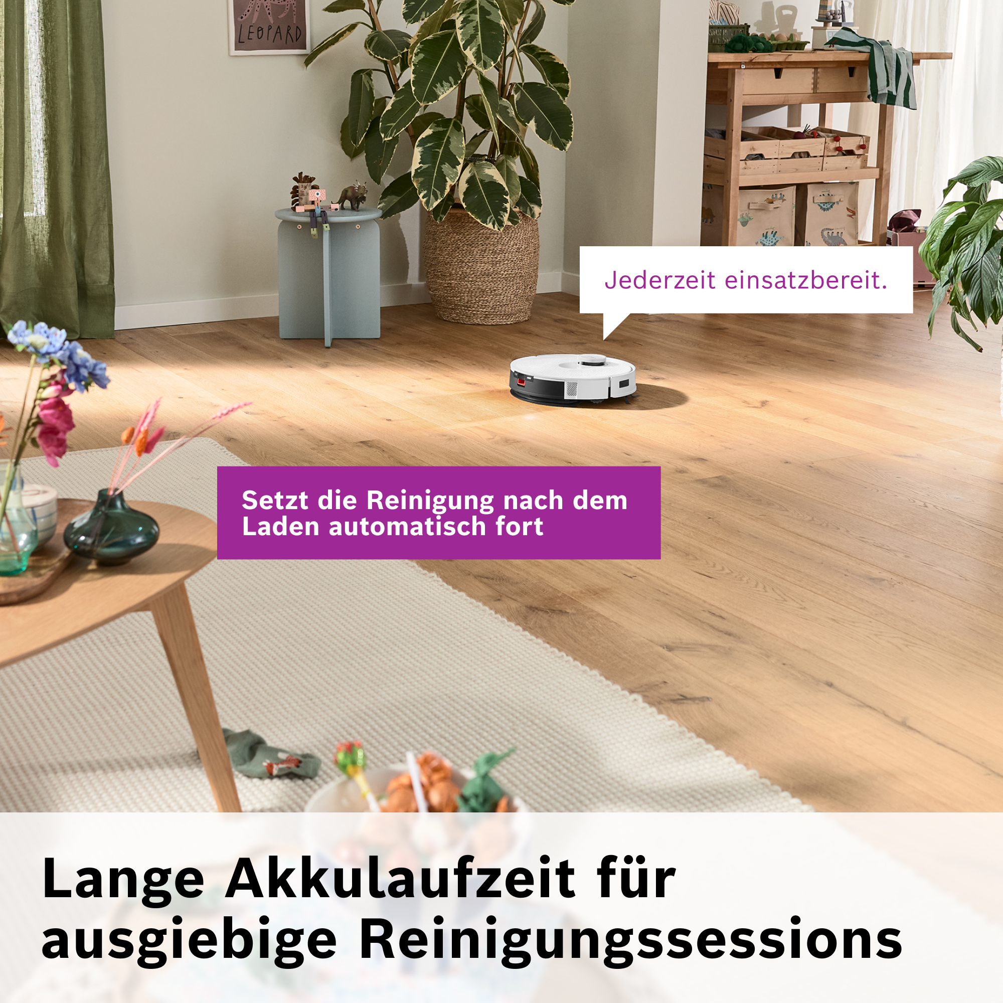 Ein Roboter-Staubsauger auf Holzboden. Ein Tisch mit Blumen, eine Pflanze und Text. Der Text lautet 'Einsatzbereit'.