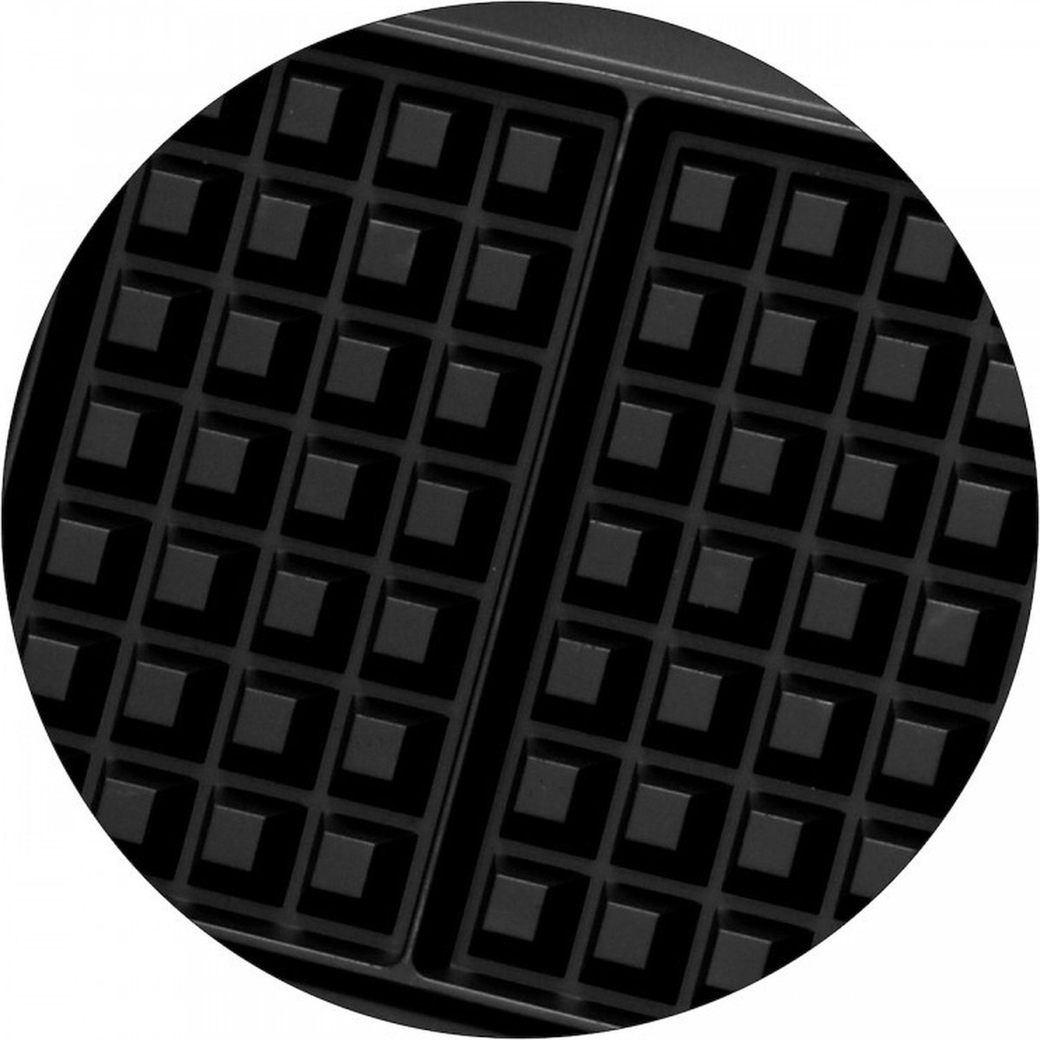 Gros plan sur la surface de cuisson d'un gaufrier. Il est noir avec un motif quadrillé d'indentations carrées, montrant la forme des gaufres.