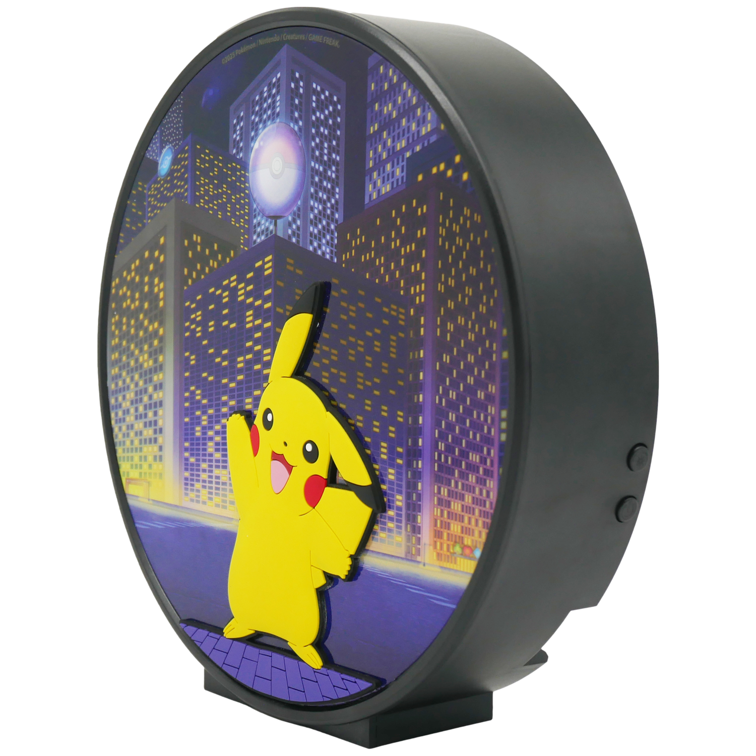 A round Pokemon lamp with Pikachu in front of a city scene at night. The lamp has a black frame and a stand.