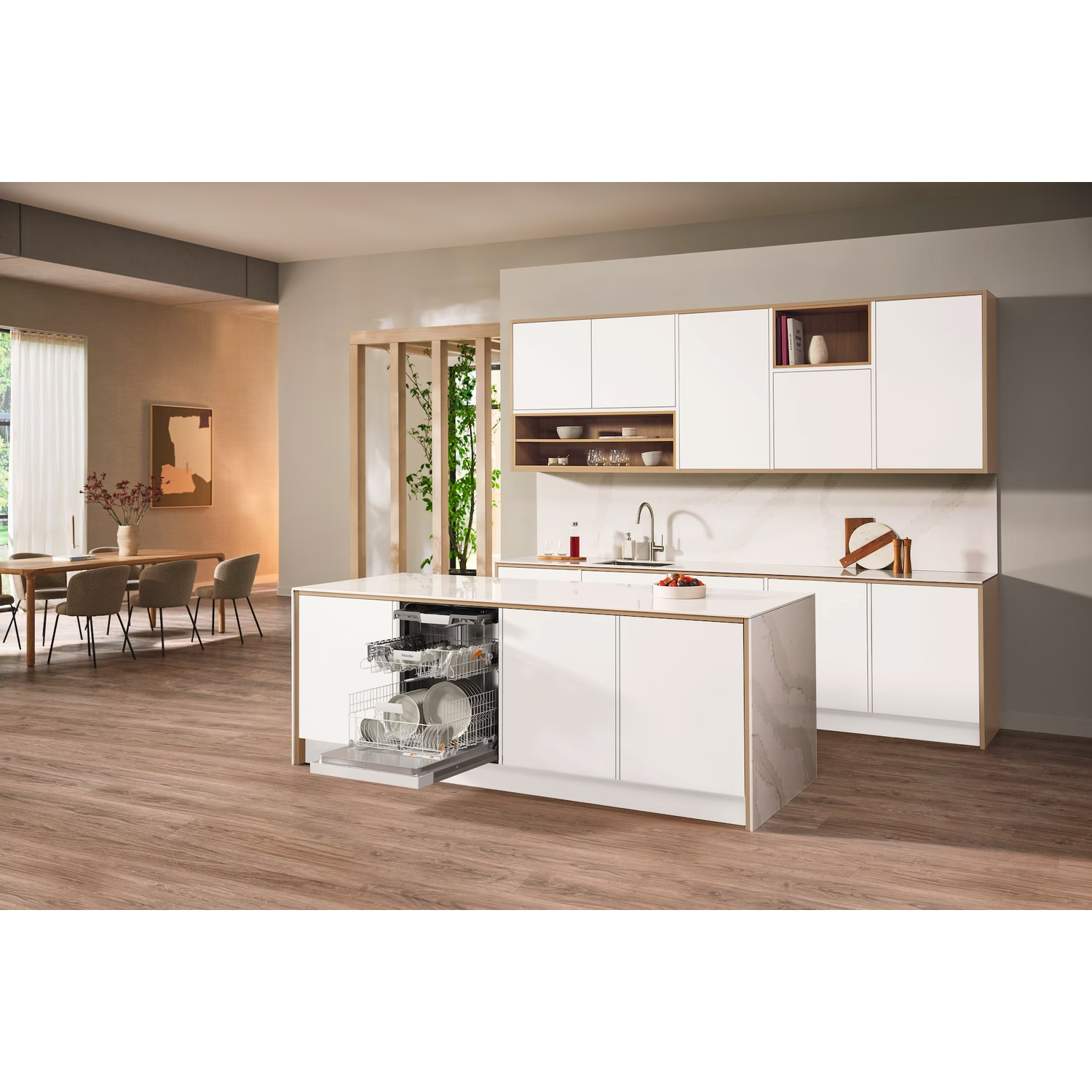 Modern kitchen with white cabinets, island with dishwasher, wooden floor, dining table, and sink area.