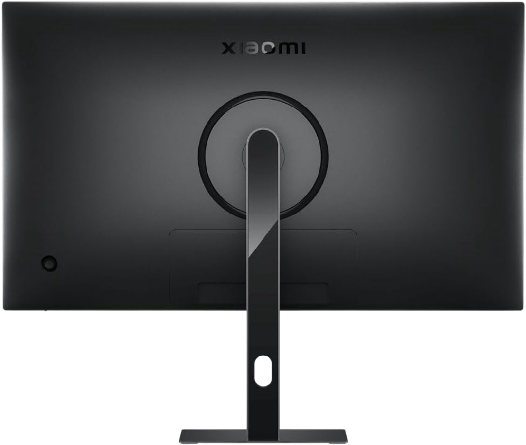 Se muestra la parte trasera de un monitor Xiaomi negro. Un soporte plateado sostiene el monitor. El logotipo de Xiaomi está arriba.