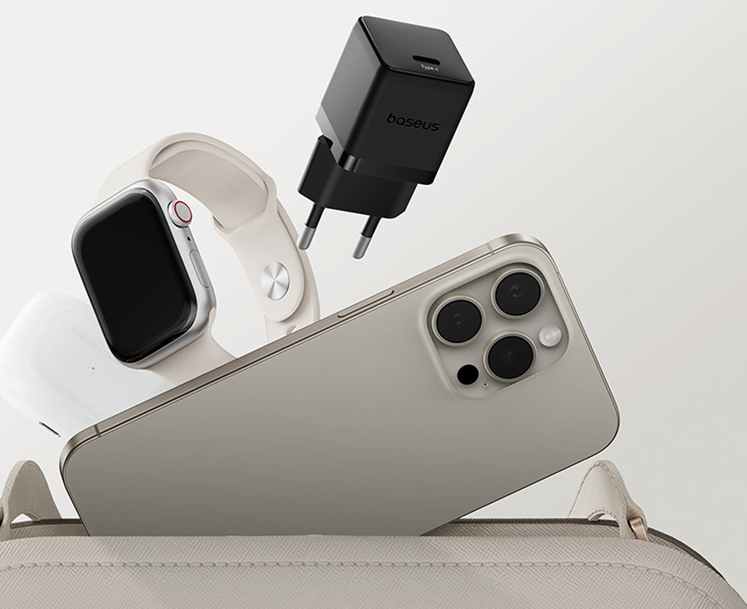 Un teléfono, un reloj, un cargador y auriculares en una bolsa. El teléfono está cerca de la bolsa, el reloj y los auriculares a la izquierda.