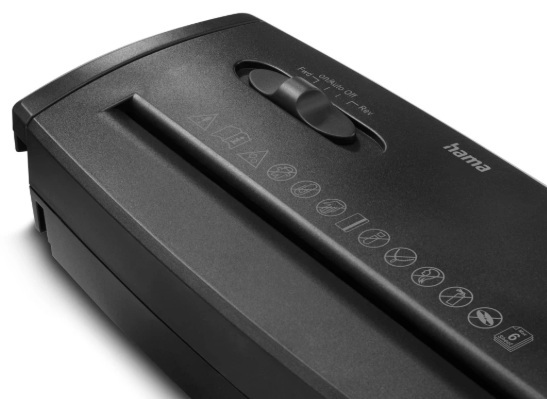 Czarna niszczarka do papieru z pokrętłem i symbolami ostrzegawczymi. Widoczna jest marka 'hama'. Niszczarka stoi na białym tle.