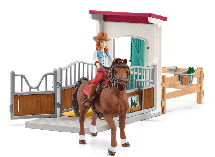 Ein Spielzeugpferd mit Reiter in einer Stallumgebung. Das Pferd ist braun, der Reiter trägt einen Cowboyhut. Der Stall hat grüne Türen.