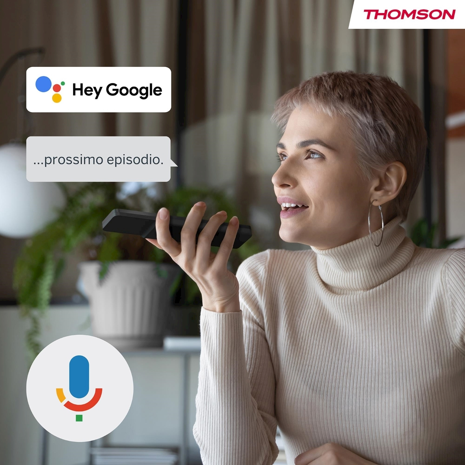 Donna che tiene in mano un dispositivo nero, parla con Google. Fumetti dicono 'Hey Google' e '...prossimo episodio.' Logo Thomson visibile.