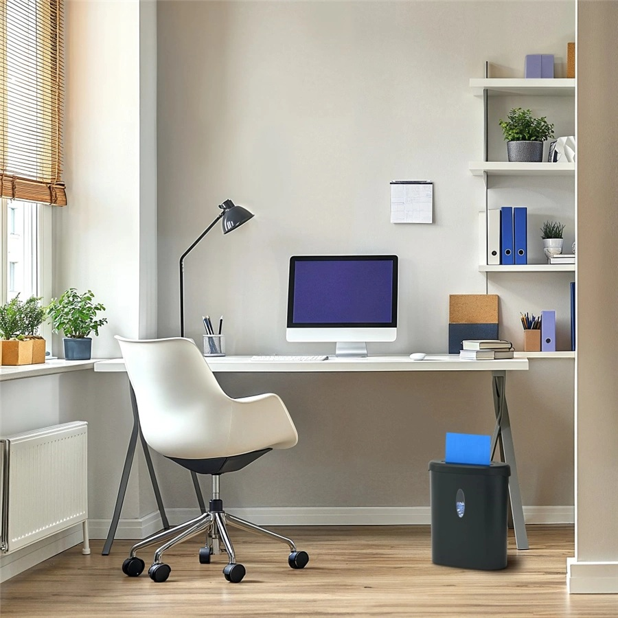 Biuro z biurkiem, komputerem, krzesłem i niszczarką. Półki z roślinami i plikami na ścianie.