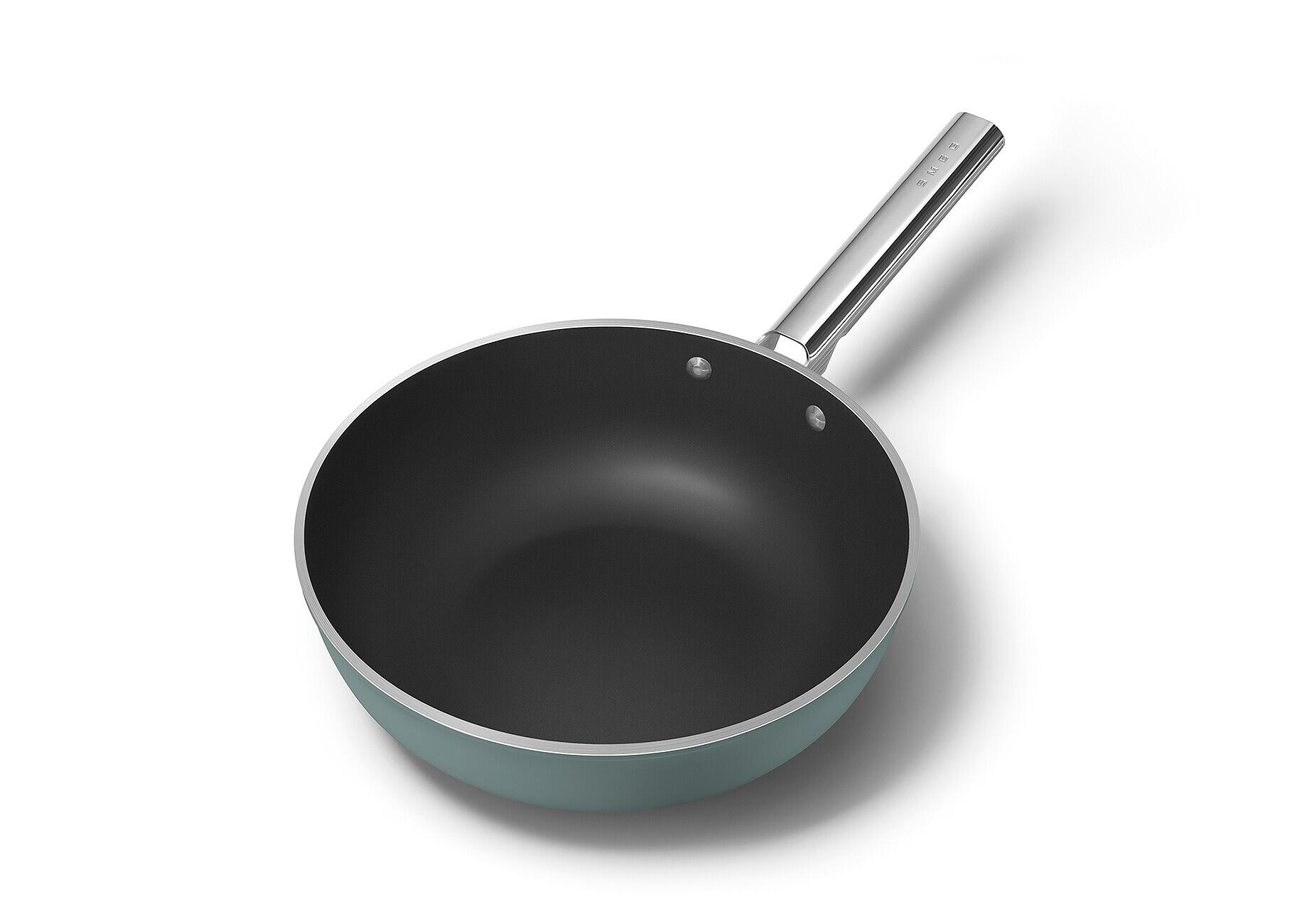 Eine türkisgrüne Bratpfanne mit silbernem Griff auf weißem Hintergrund. Die Pfanne hat einen schwarzen Innenraum. Der Griff hat das Wort SMEG.