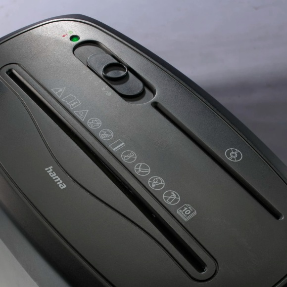 Czarna niszczarka do papieru z zielonym światłem i symbolami. Widoczna marka 'hama'.