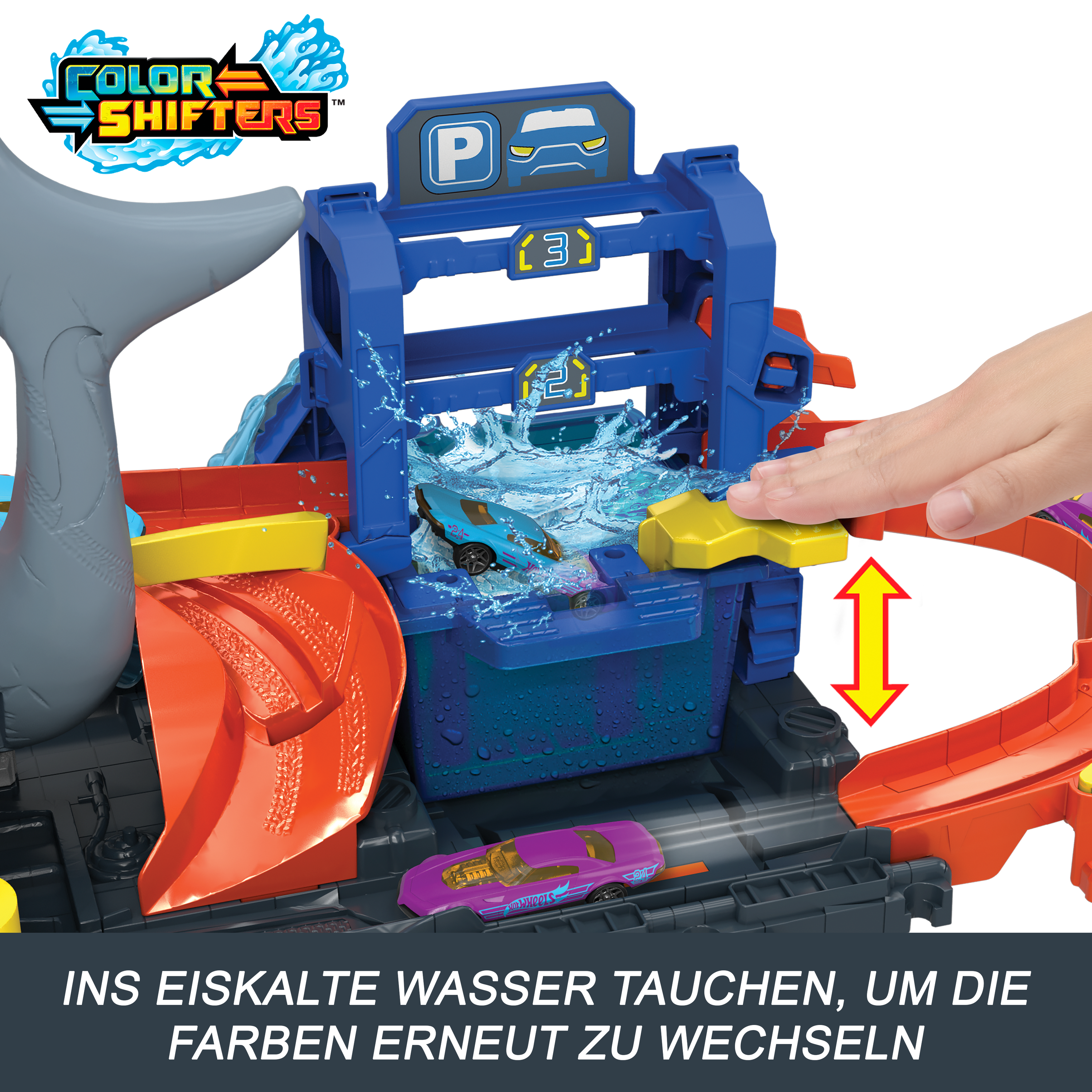 Ein Spielzeug-Autowaschanlage mit blauem Auto. Wasser spritzt von oben. Eine Hand drückt einen Knopf.