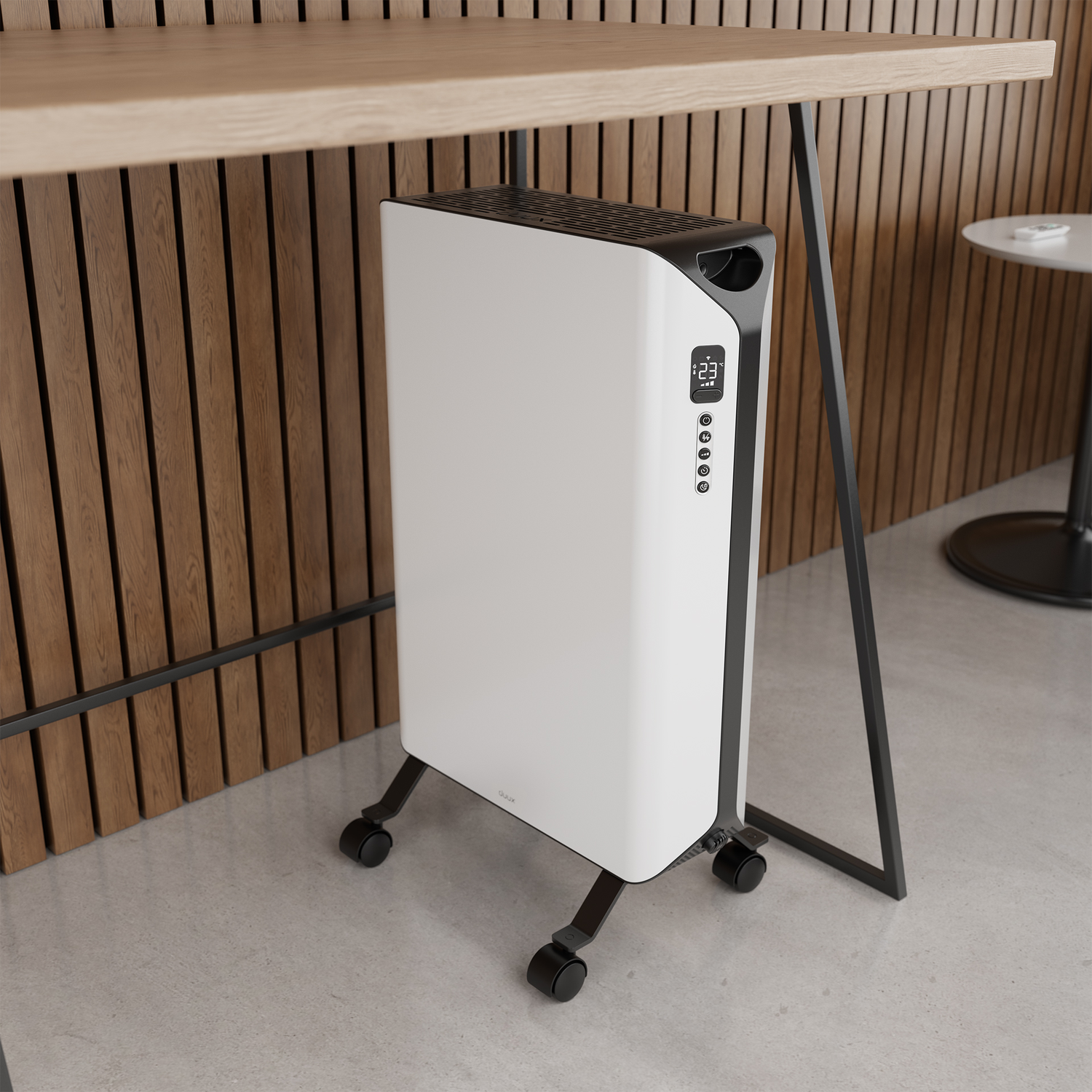 Een wit-zwarte kachel met digitaal display, onder een houten tafel, bij een houten muur. Wielen zijn zichtbaar.