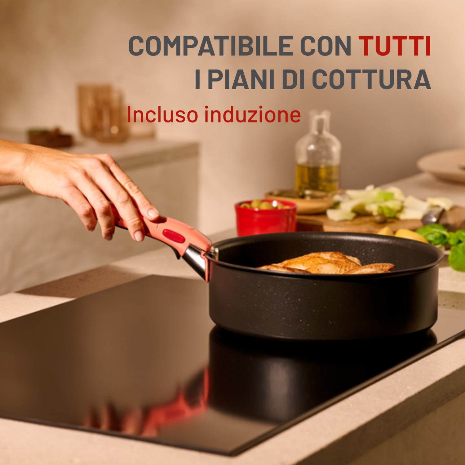 Una mano tiene una padella con manico su un piano cottura nero. Testo: 'COMPATIBILE CON TUTTI I PIANI DI COTTURA'.