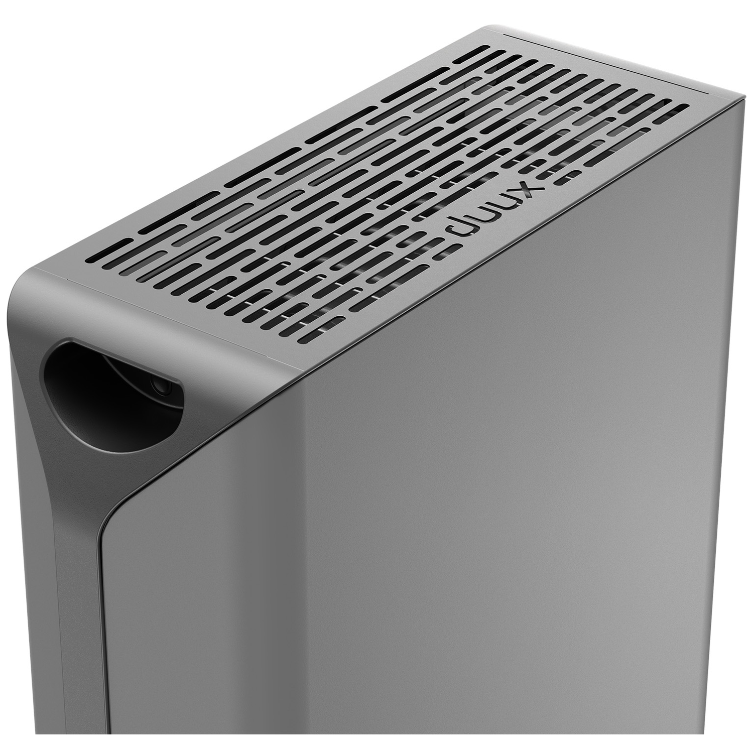 Een grijs rechthoekig elektronisch apparaat. De bovenkant heeft ventilatiesleuven, met het merk 'duux'. Het heeft een gebogen handvat aan de zijkant.