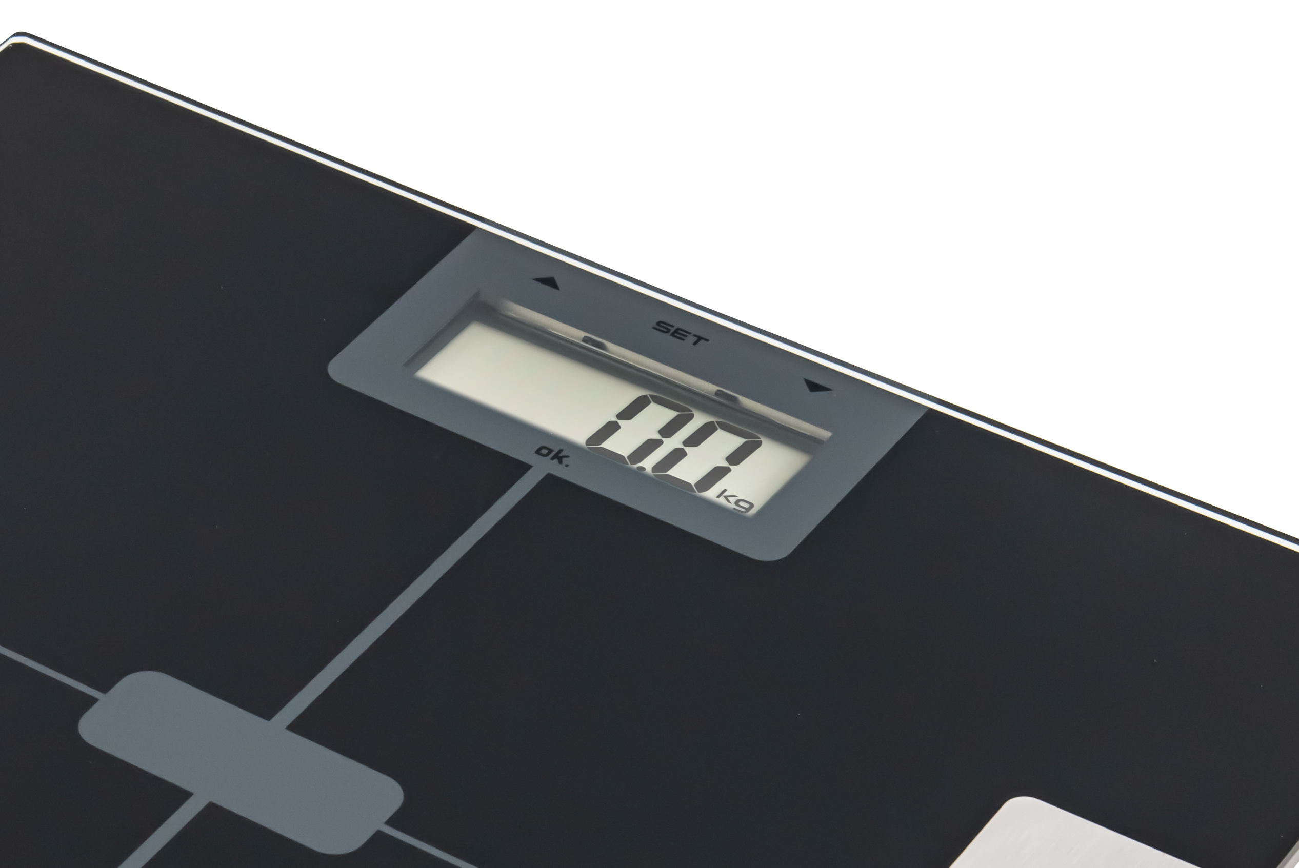 Waga cyfrowa pokazująca '0,0 kg'. Waga jest czarna z szarą ramką wyświetlacza. Tło jest czarne.