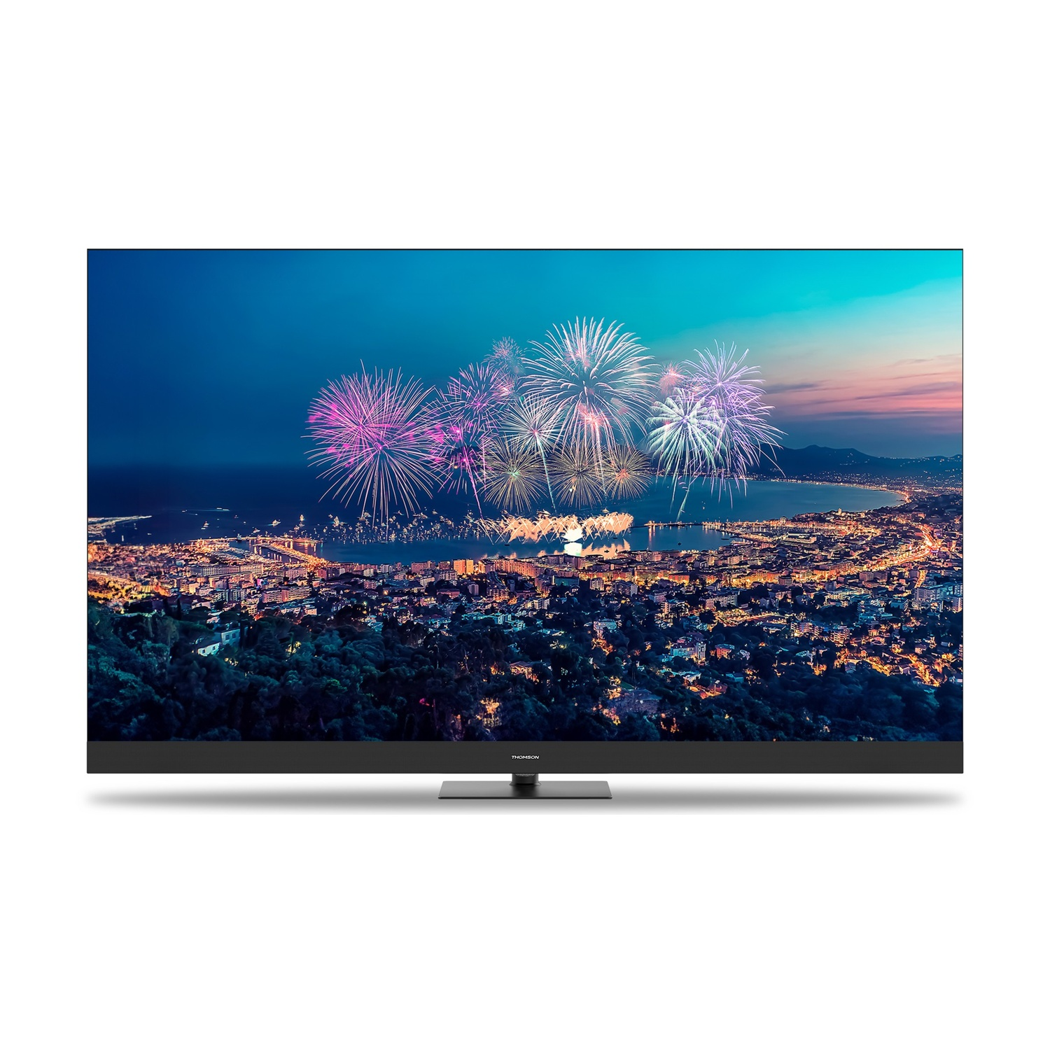 La TV mostra uno spettacolo di fuochi d'artificio su una città. I fuochi d'artificio esplodono con colori su una città costiera al crepuscolo.
