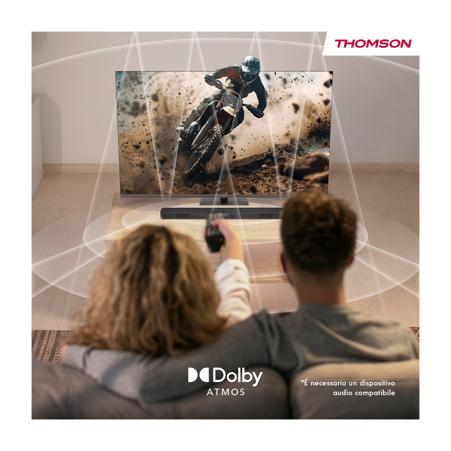 Una coppia guarda la TV. Lo schermo mostra un pilota di motocross. Una soundbar è sotto la TV. Logo Dolby Atmos in basso a sinistra.