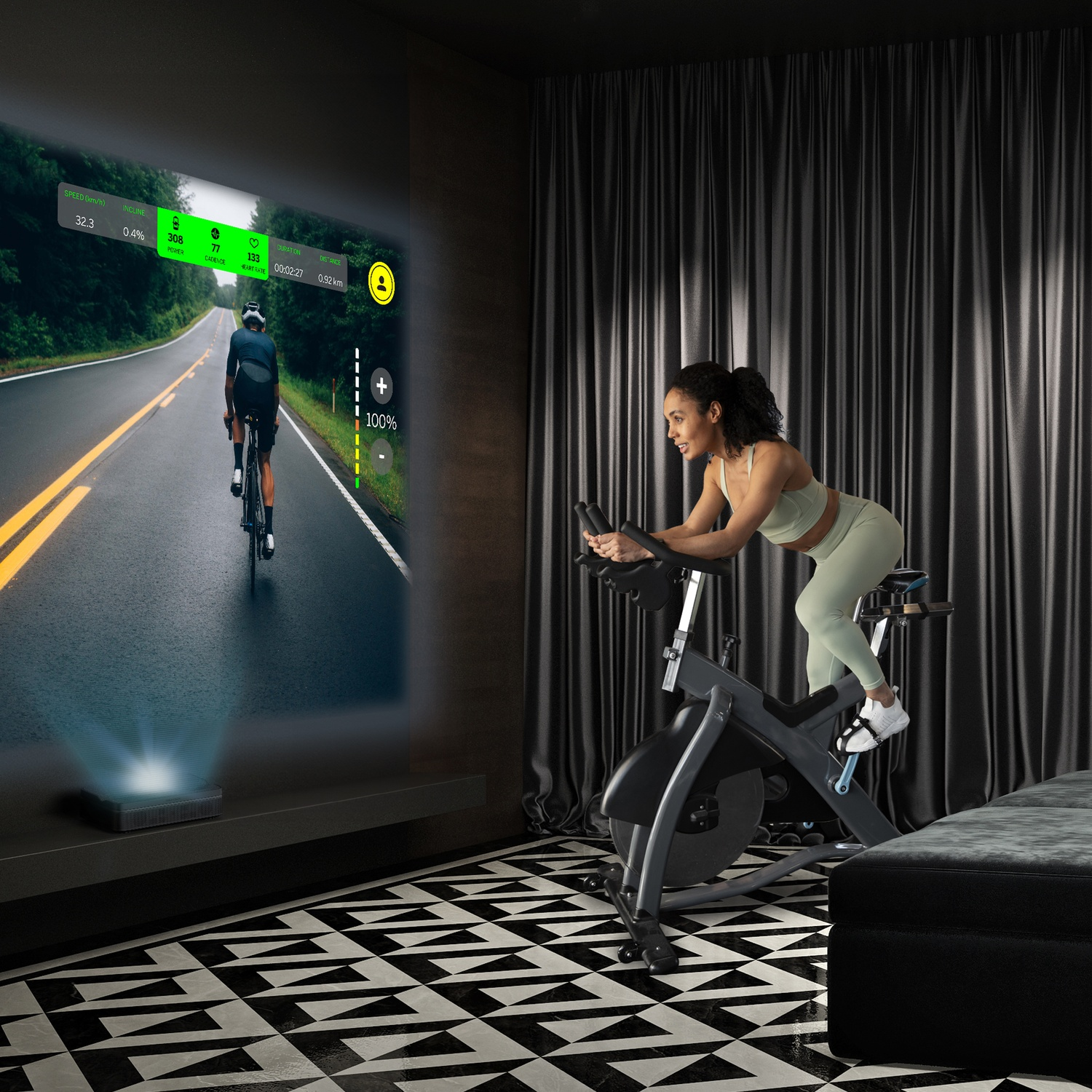 Una donna si esercita su una cyclette, guardando un video di ciclismo proiettato su un muro. La stanza ha un pavimento a motivi e tende scure.