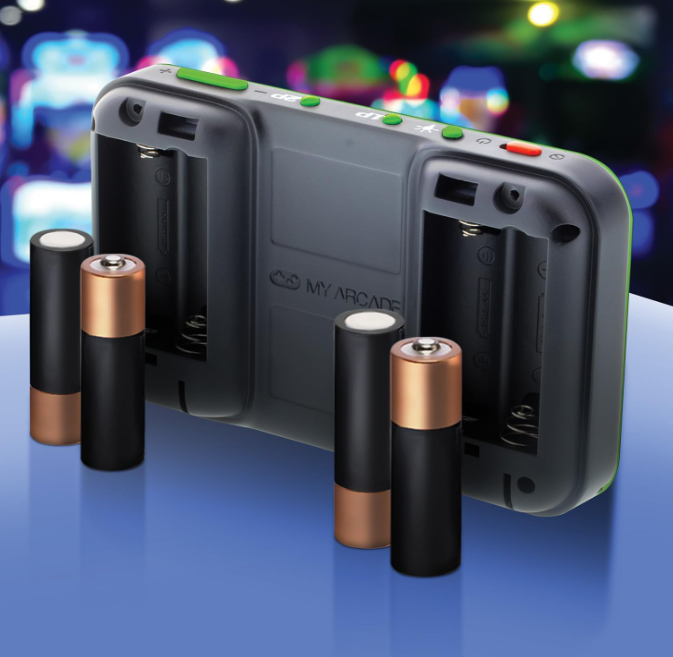 Ein tragbares Spielgerät mit Batteriefächern und mehreren AA-Batterien. Das Gerät ist schwarz und grün. Der Hintergrund ist verschwommen.