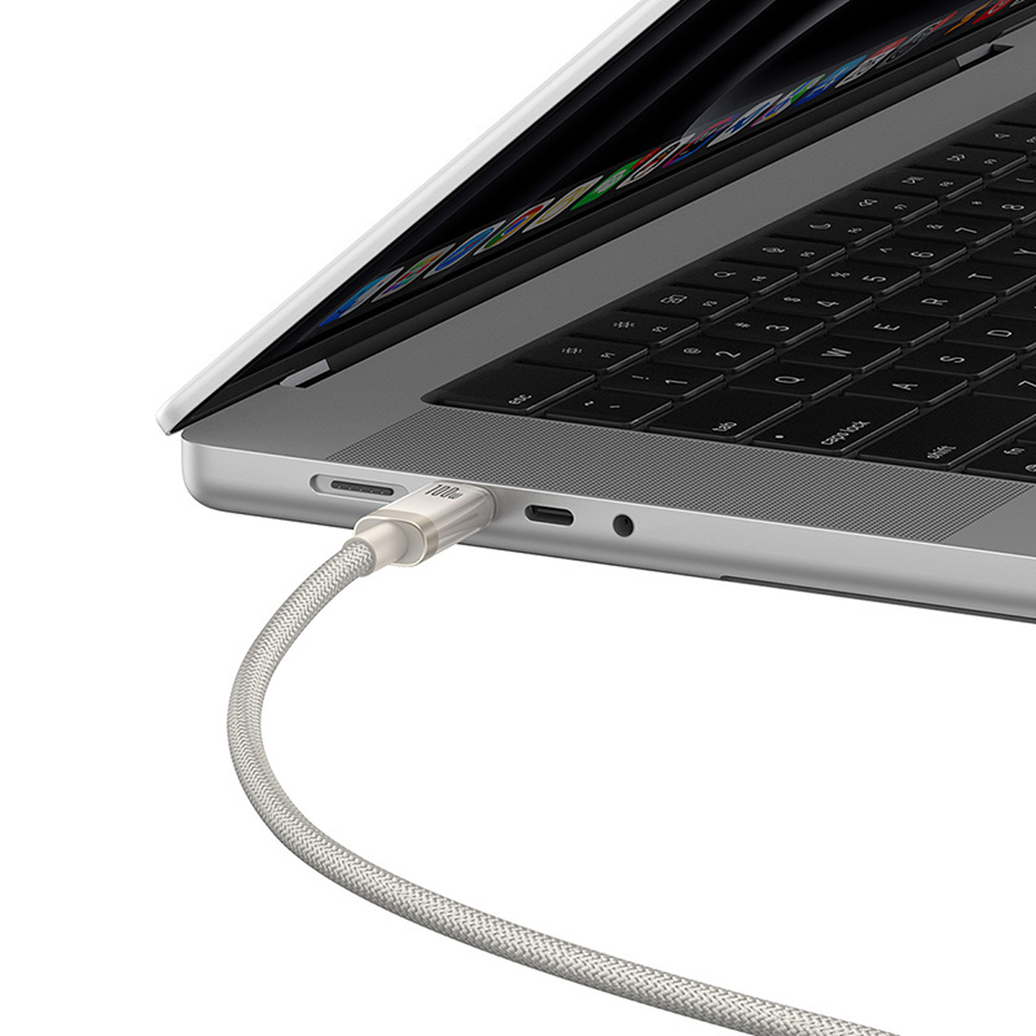 Un portátil con un cable plateado enchufado. El cable está conectado al portátil. El portátil está abierto, mostrando el teclado.