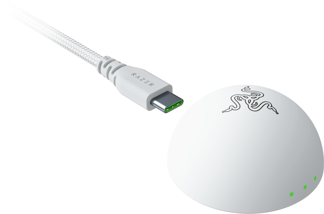 Weißes Razer-Ladegerät und -Kabel. Das Kabel hat Razer-Branding und einen USB-C-Anschluss. Die Basis hat das Razer-Logo und drei grüne Lichter.