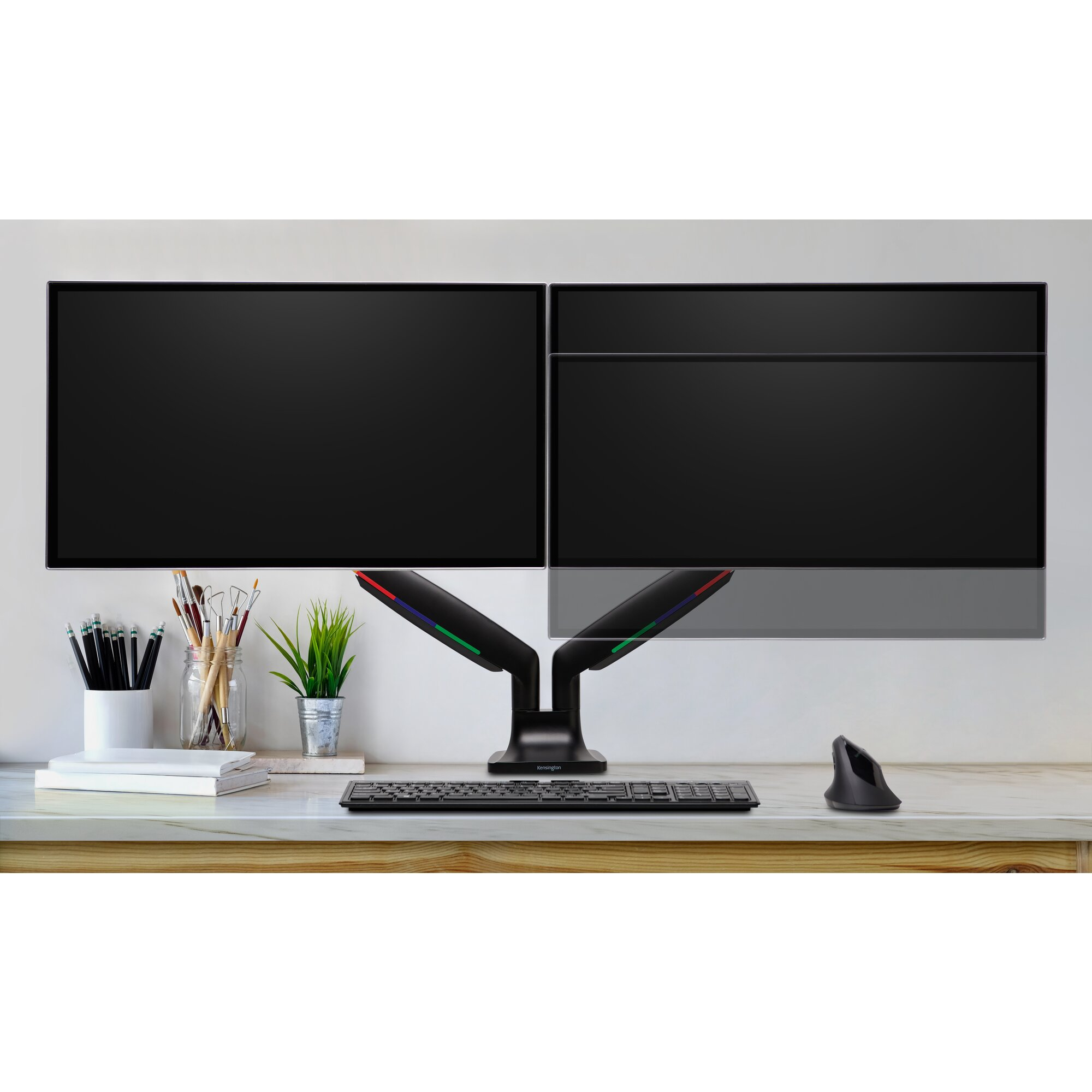 Zwei Monitore auf einem Schreibtisch mit Tastatur, Maus und Büromaterial. Die Monitore sind schwarz.