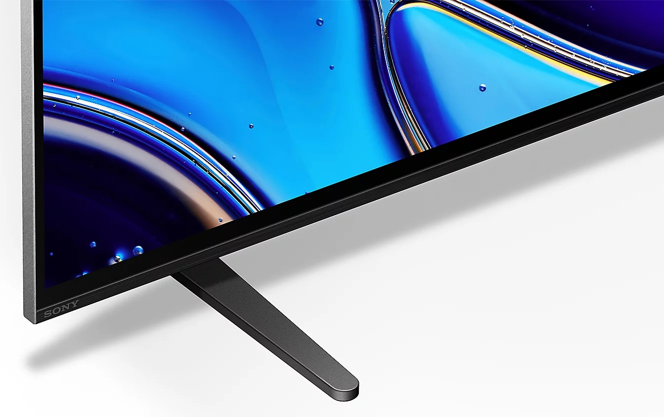 Ekran telewizora wyświetla niebieską sztukę abstrakcyjną. Czarna ramka i stojak podtrzymują telewizor. Widoczne jest logo Sony.