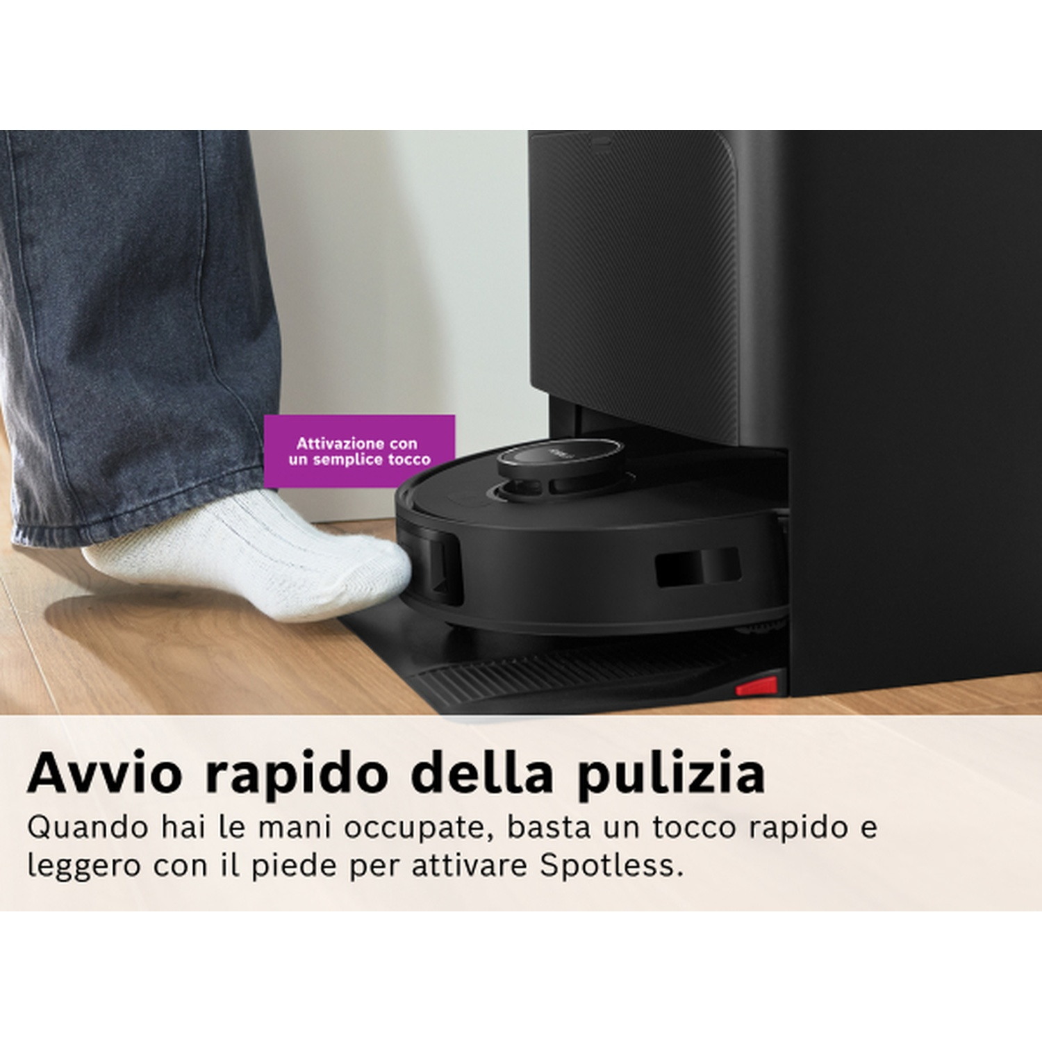 Un piede attiva un aspirapolvere robot. Il testo dice: 'Pulizia rapida'. L'aspirapolvere è nero e la persona indossa calzini.