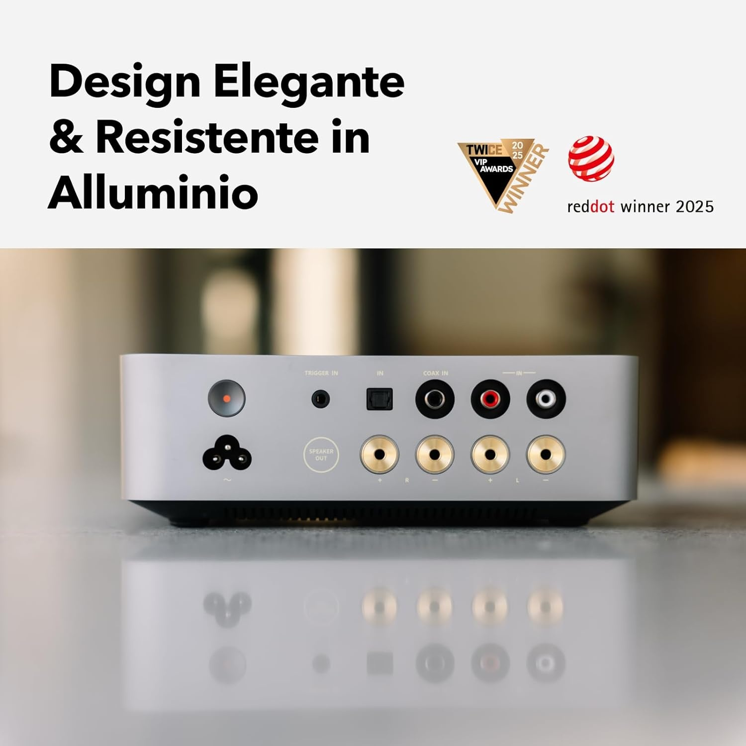 Dispositivo audio argento con ingressi e uscite multiple, riflesso in basso. Testo: Design Elegante & Resistente in Alluminio. Vincitore Reddot.