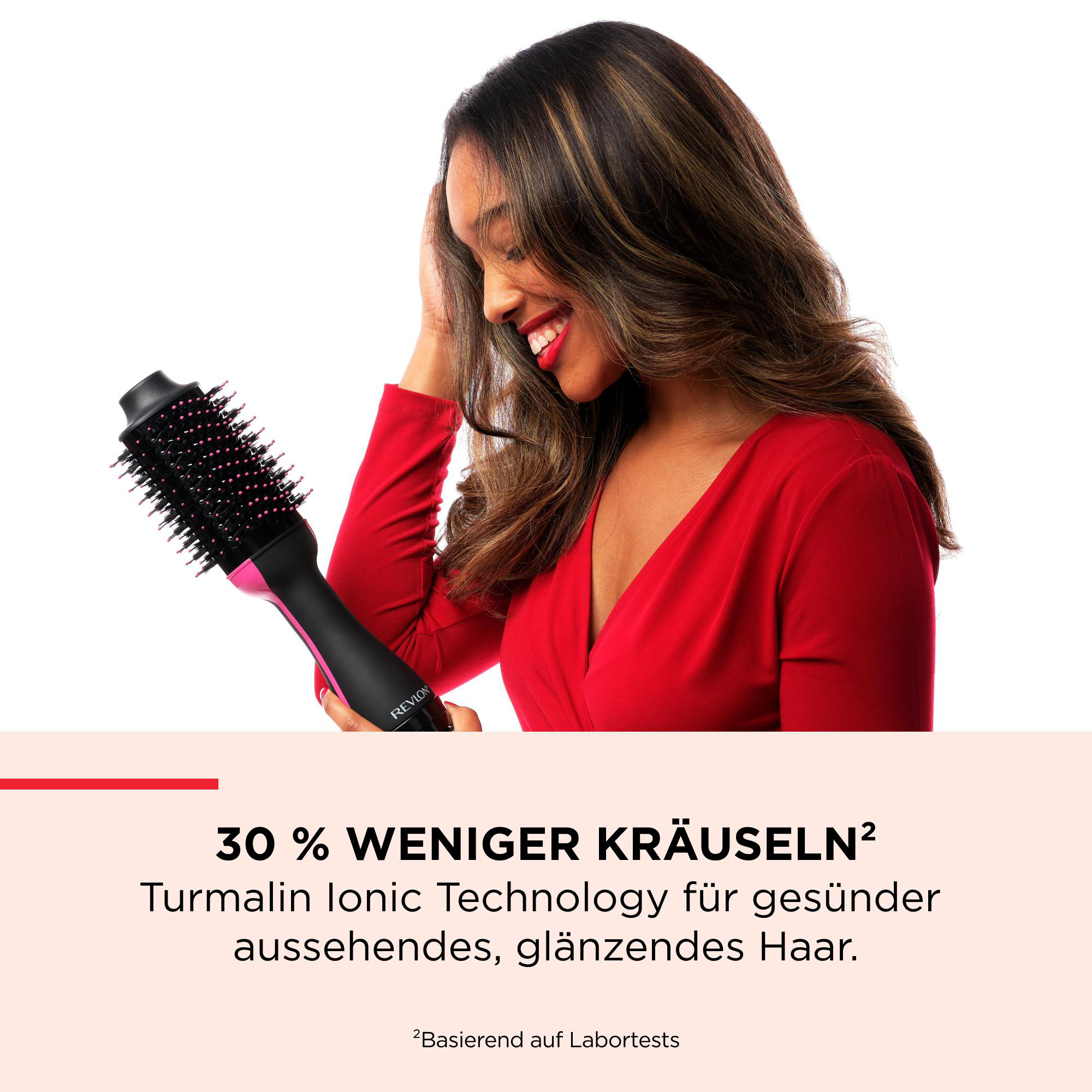 Frau mit Haartrockner, lächelt. Sie trägt ein rotes Kleid. Text: 30 % weniger Frizz. Haare glänzen.