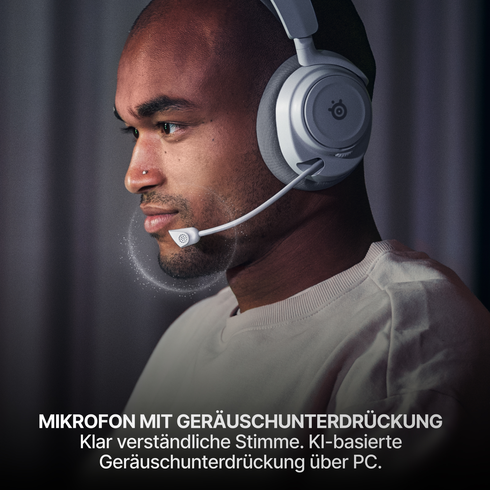 Ein Mann mit weißen Kopfhörern und Mikrofon. Das Mikrofon befindet sich in der Nähe seines Mundes. Der Hintergrund ist dunkel und verschwommen.